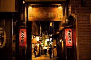 Stone-paved Hozenji Yokocho alley illuminated by traditional lanterns in Osaka