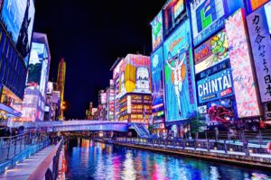 Vibrant neon signs and crowds along the Dotonbori canal at night in Osaka)