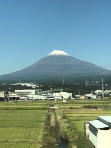 Snow-capped Mount Fuji visible from the window of a speeding Shinkansen